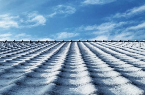 Detail of a roof  with clay tiles  covered with snow in winter.